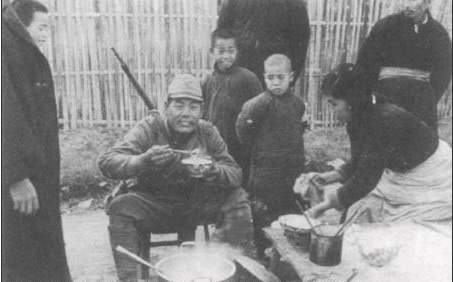 1937年12月15日，南京中山北路东侧安全区附近，营业的中国人露天饮食小摊，日本兵在吃水饺