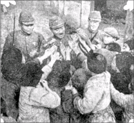 1938年1月16日，日本军官在给中国小孩分发糖果