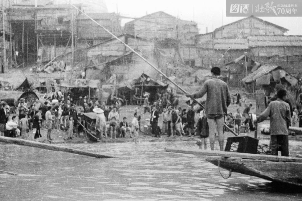 图为1940年，日军轰炸重庆市区，市民纷纷坐船逃难。