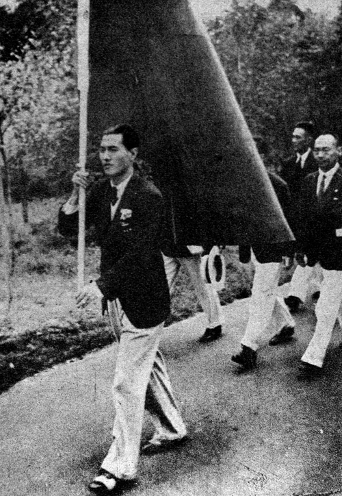 1936年李惠堂持旗进入柏林奥林匹克村。