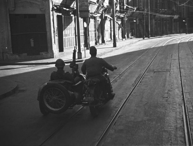 日军士兵驾驶边三轮摩托车在荒凉的街道上。1937年。